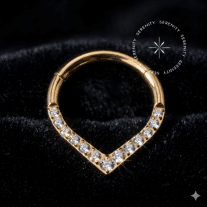 Argola septo titânio dourado em formato de gota ou V, com cravação frontal de pedras zircônia premium translúcidas, sistema de encaixe articulado clicker, ideal para perfurações de septo e daith.