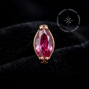 Topo piercing titânio dourado com lapidação navete em gema vermelho profundo, envolta por finas garras de fixação. Conta com pino de rosca interna de 0.9mm na base traseira, indicado para iluminação sofisticada de cartilagem e lóbulo.