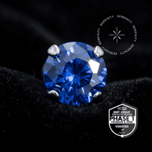 piercing titânio grau implante modelo topo prongset cravejado com zircônia azul escuro, repousando suavemente sobre um tecido de cetim branco de alta opulência.