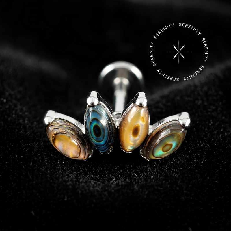 piercing titânio grau implante com design cluster de 11mm e quatro autênticas pedras naturais abalone repousando suavemente sobre um tecido de cetim branco de alta opulência.