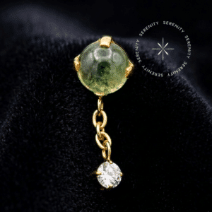 Topo Titânio Dourado apresentando design pendente com corrente fluida, peridoto cultivado em laboratório na extremidade superior e zircônia translúcida na base.