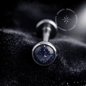 Piercing Topo Titânio repousando suavemente sobre um tecido de cetim preto de alta opulência, exibindo sua pedra natural ônix com pontos brilhantes perfeitamente protegida por uma moldura lisa e polida.