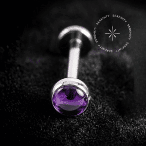 Piercing Topo Titânio repousando suavemente sobre um tecido de cetim preto de alta opulência, exibindo sua pedra natural ametista de 4mm perfeitamente protegida por uma moldura lisa e polida.