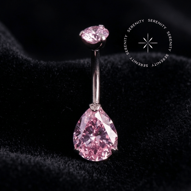piercing umbigo titânio com design de curvatura em formato gota adornado por zircônias rosas de lapidação premium, repousando suavemente sobre um tecido de cetim branco de alta opulência.
