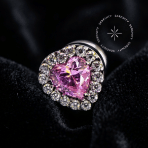 piercing titânio grau implante com design de coração adornado por zircônia rosa central e halo de zircônias translúcidas, repousando suavemente sobre um tecido de cetim branco de alta opulência.