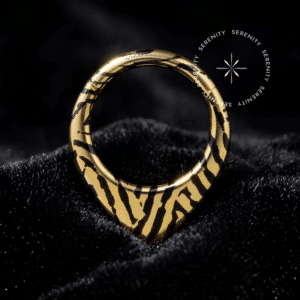 Piercing Argola Septo Titânio repousando suavemente sobre um veludo de seda preto de alta opulência, destacando o formato em V e a estampa listrada contrastante.