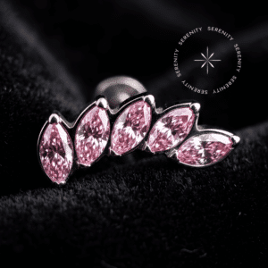 piercing titânio grau implante com design em cluster adornado por cinco zircônias rosas de lapidação marquise, repousando suavemente sobre um tecido de cetim branco de alta opulência.