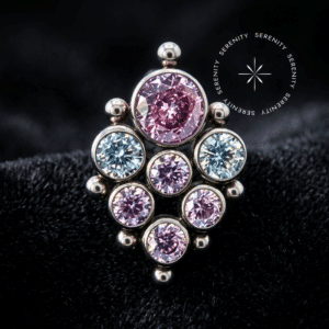 piercing titânio grau implante com design ornamental adornado por zircônias rosas e translúcidas e detalhes em granulação metálica, repousando suavemente sobre um tecido de cetim branco de alta opulência.
