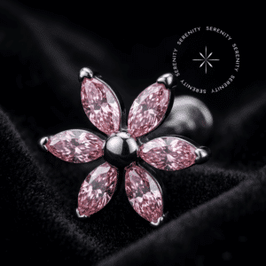 piercing titânio grau implante com design floral adornado por seis zircônias rosas em lapidação marquise e centro liso, repousando suavemente sobre um tecido de cetim branco de alta opulência.