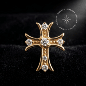 Fotografia em modo macro de um piercing titânio dourado em formato de cruz, cravejado com zircônias translúcidas repousando suavemente sobre um tecido de cetim branco de alta opulência.