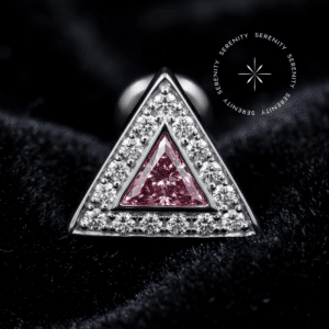 Topo Triângulo Cravejado Titânio exibindo zircônias de lapidação premium rosa e translúcida, repousando suavemente sobre um tecido de cetim branco de alta opulência.