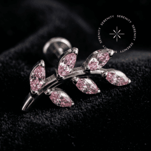 Topo Folhas Cravejadas Titânio exibindo ramificação delicada com zircônias de lapidação premium rosas, repousando suavemente sobre um tecido de cetim branco de alta opulência.