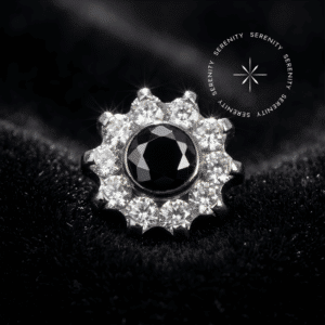 Piercing Labret topo flor 10 pétalas cravejado com zircônias translúcidas e centro preto em titânio grau implante natural repousando suavemente sobre um tecido de cetim branco de alta opulência.