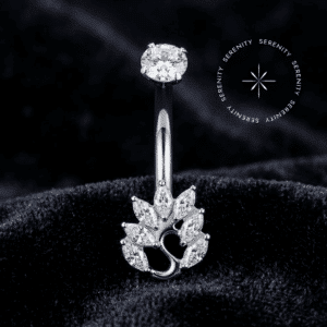 Piercing Umbigo Titânio repousando suavemente sobre um tecido de cetim branco de alta opulência, evidenciando o design de cisne finamente cravejado com zircônias translúcidas.