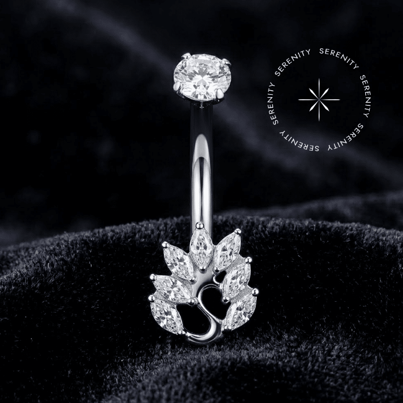 Piercing Umbigo Titânio repousando suavemente sobre um tecido de cetim branco de alta opulência, evidenciando o design de cisne finamente cravejado com zircônias translúcidas.