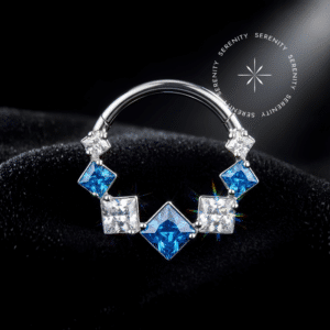 Piercing Argola Daith Titânio repousando suavemente sobre um tecido de cetim branco de alta opulência, destacando o sistema clicker frontal com zircônias azuis e translúcidas e o polimento espelhado.