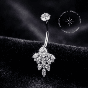 Piercing Umbigo Titânio repousando suavemente sobre um tecido de cetim branco de alta opulência, evidenciando o cluster floral inferior finamente cravejado com zircônias translúcidas.